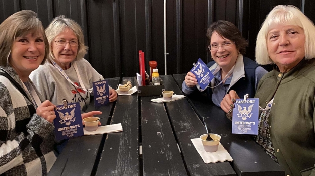 A group of friends shows off their Passports and enjoys a sample during last year's Downtown Restaurant Tour.